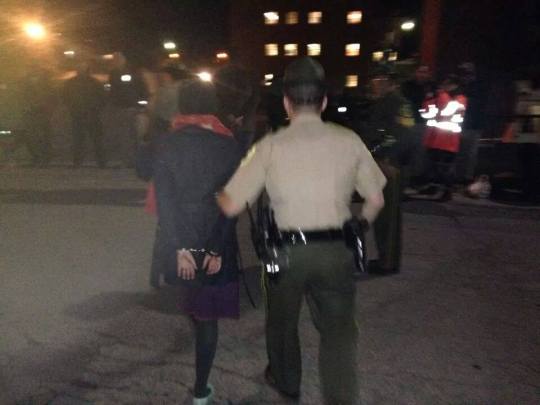 Maeve McBride, organizer for 350 Vermont and mother of two being led away from Governor Peter Shumlins office on Monday night.  63 other protestors were arrested with her.